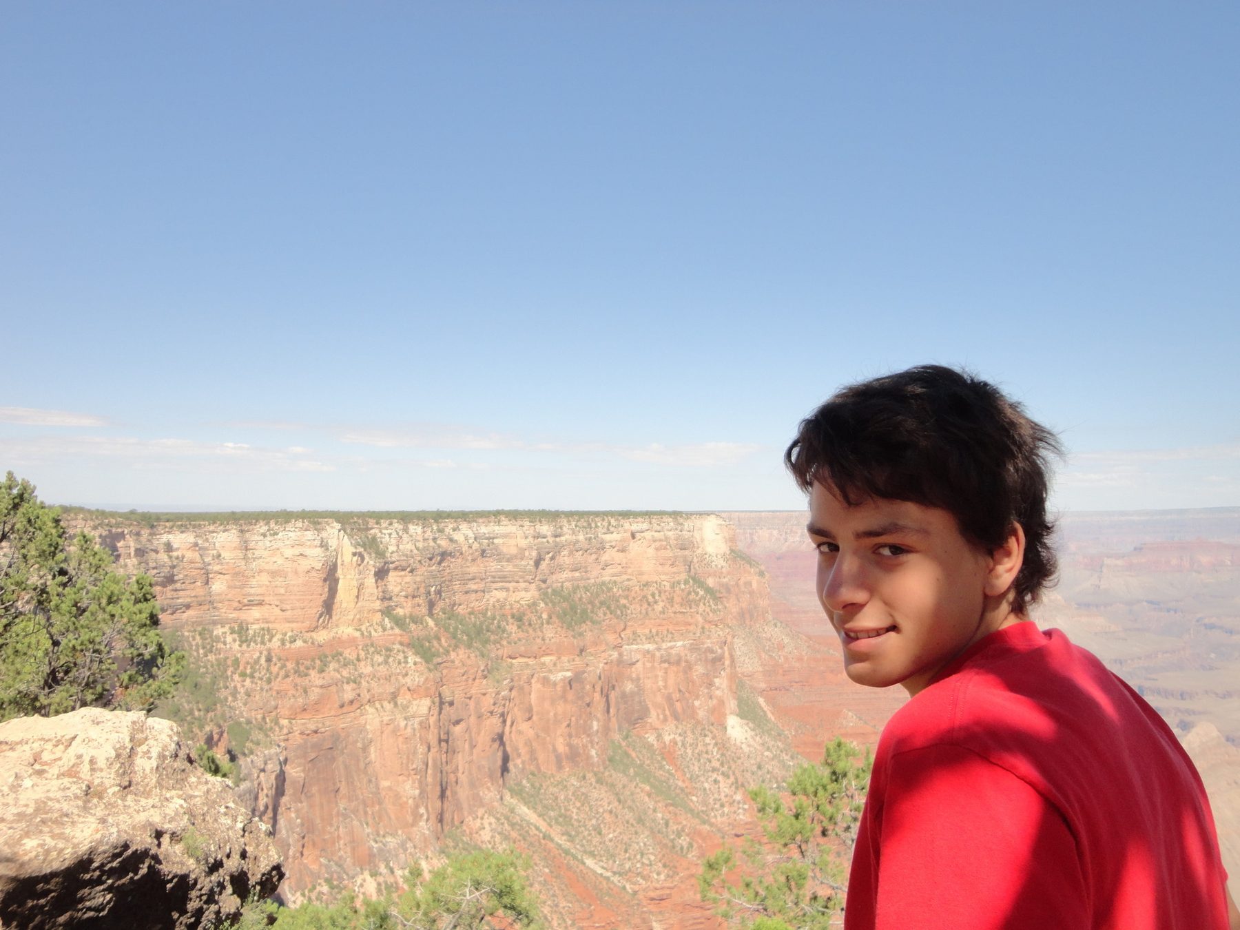 Marco Gallo con maglietta rossa, sguardo verso l&rsquo;obiettivo, canyon sullo sfondo.