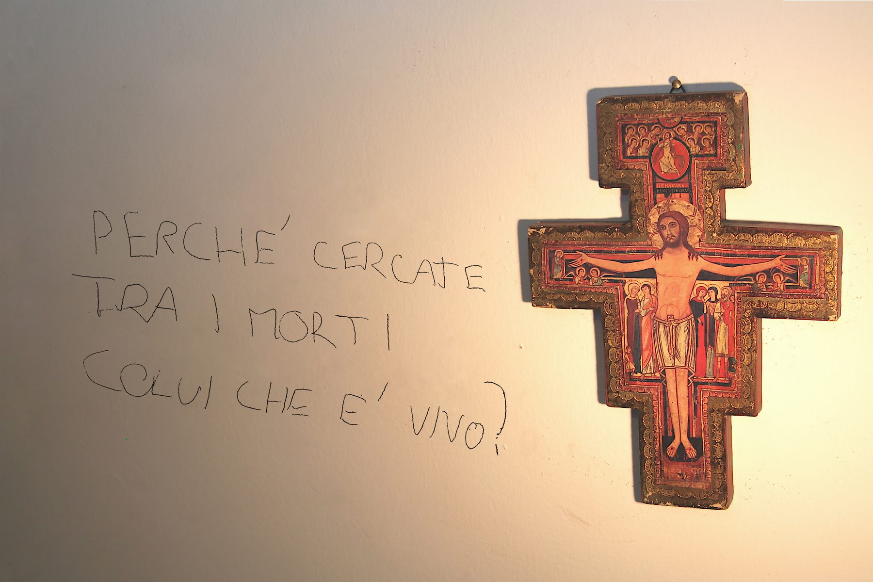 La scritta lasciata da Marco sul muro della sua camera, accanto al crocifisso di San Damiano: «Perché cercate tra i morti colui che è vivo?»